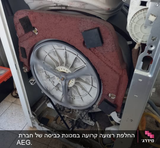 מכונת כביסה פתוחה עם תוף חשוף וחוטי חשמל